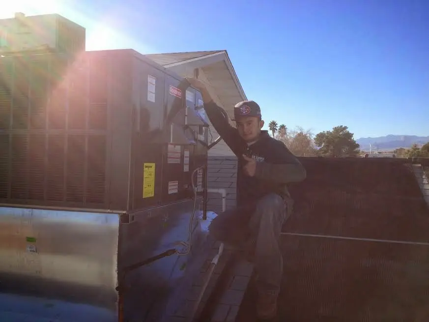 HVAC technician performing Air Duct Cleaning on a rooftop unit in Lawrence